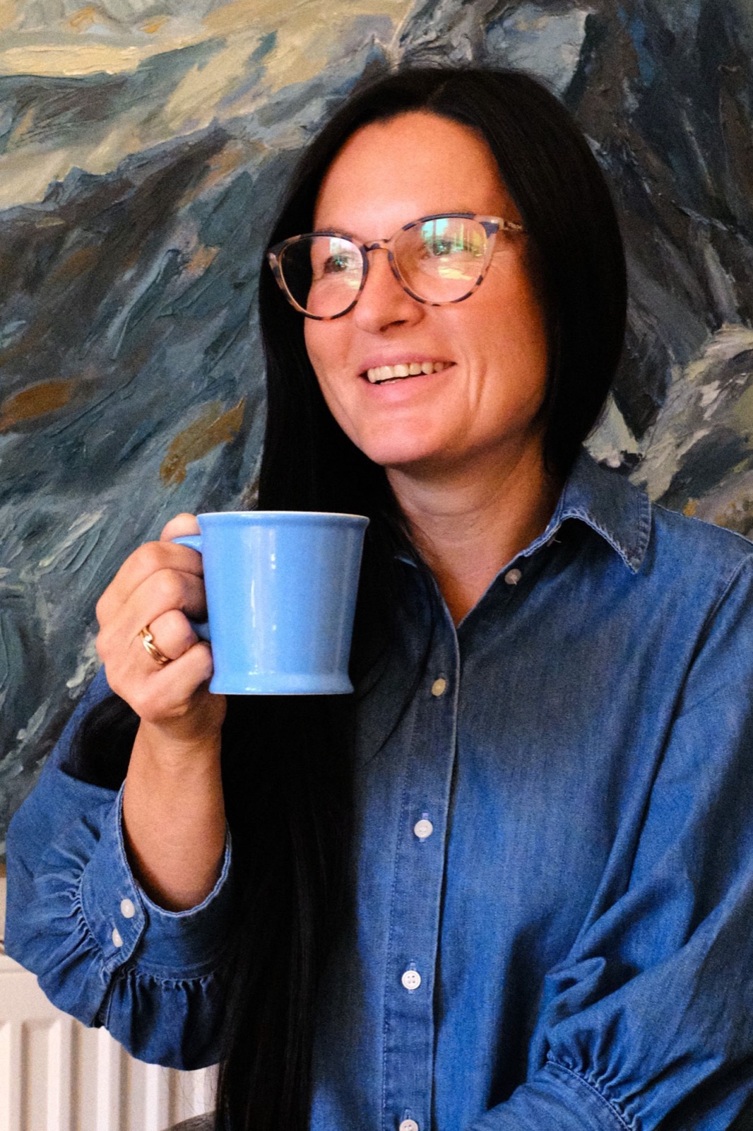 Diana laughing, holding a blue mug